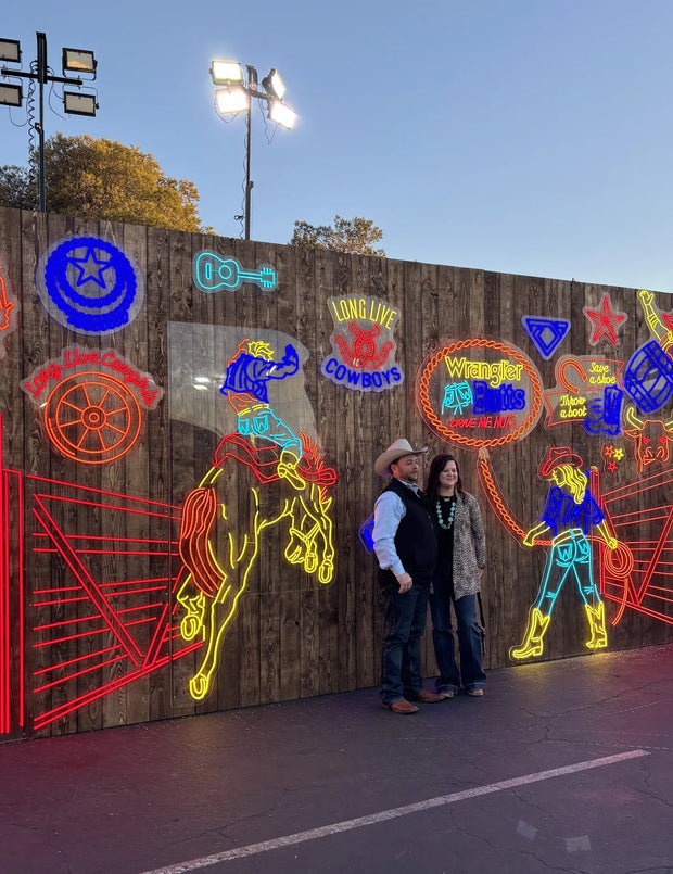 Neon western cowboy photo wall with rodeo and Wrangler Boots signs