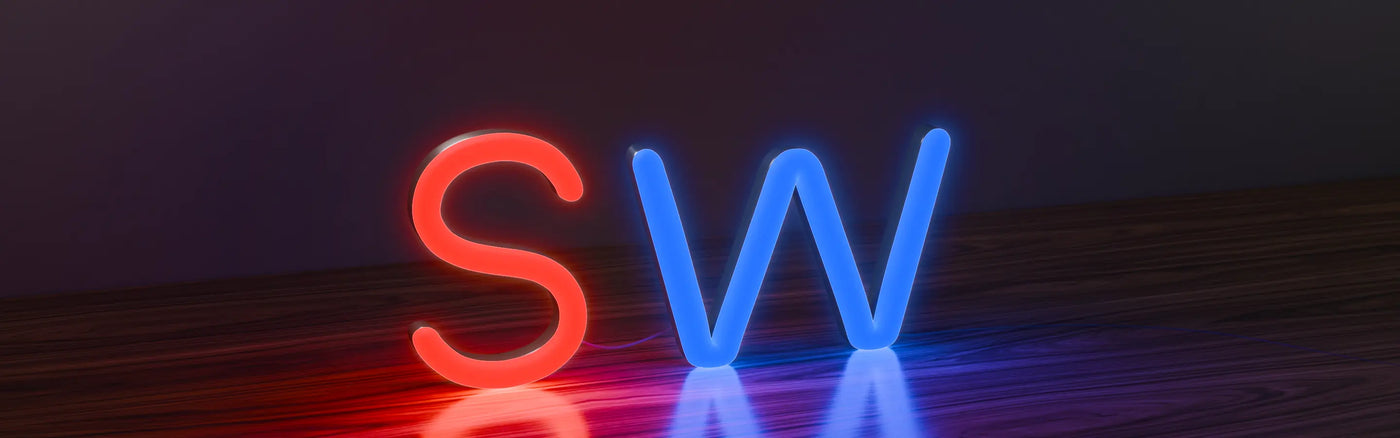 On acrylic neon signs in the shape of the letters 'S' glowing red and 'W' glowing blue, standing on a wooden surface against a dark background.