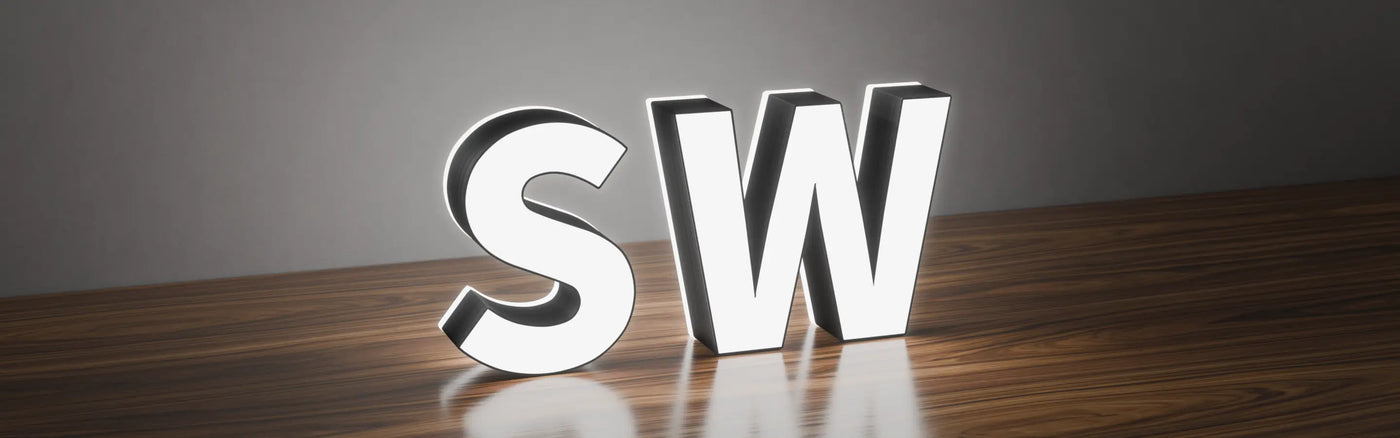 Face and edge lit 3D letters 'S' and 'W' with glowing white faces and edges, illuminated on a wooden surface with a dark grey background