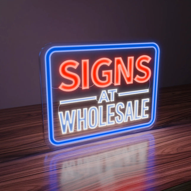 On uv-printed neon sign reading 'SIGNS AT WHOLESALE' on a wooden surface